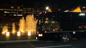 Night scene of Black VIP Party Bus parked in front of the Crown Center fountain